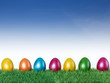 Happy Easter! Colourful eggs in the meadow with blue sky