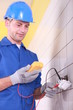 electrician is checking an outlet with an ammeter