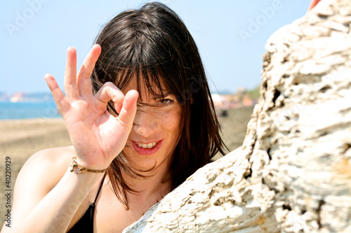 Photo: Happy female model on the beach with wind blowing in her hair Happy female model on the beach with wind blowing in her hair