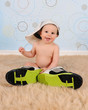 sweet baby boy wearing his Daddy's hat and sneakers
