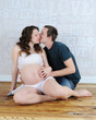 Photo: man lovingly kissing expectant womans cheek man lovingly kissing expectant womans cheek