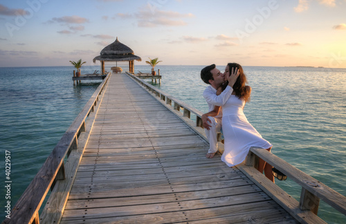 Photo: Sensual happy couple with white clothes on a pier (Maldives) Sensual happy couple with white clothes on a pier (Maldives)