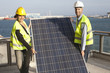 Engineers carry solar panel