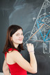 Pretty young college student writing on the chalkboard/blackboar