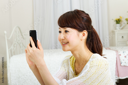Foto: Asian beautiful woman using a mobile phone Asian beautiful woman using a mobile phone