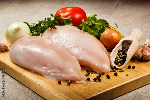 Photo: Raw chicken breasts on cutting board Raw chicken breasts on cutting board
