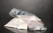Cocaine and drugs in packages, dollars on grey background
