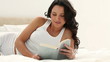 Brunette haired woman reads a book