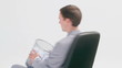 Businessman sitting while holding a wastebasket