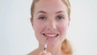 Smiling woman using a lip brush