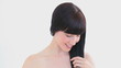 Smiling brunette brushing her hair