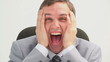 Nervous man placing his hands on his cheeks