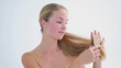 Smiling woman brushing her fair hair