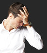 Angry young man doing frustration gesture over black background