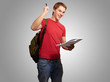 portrait of handsome student holding notebook and pen over grey