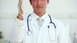 Doctor putting a latex glove on his hand