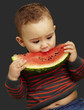 portrait of a handsome kid holding a watermelon and sucking over