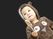 portrait of a handsome kid wearing a brown bear sweatshirt holdi