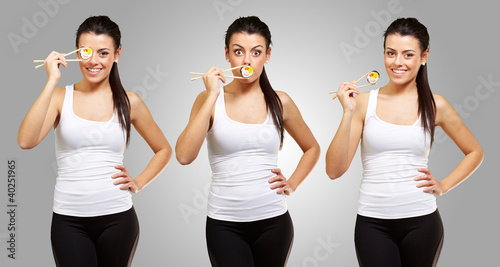 Photo: portrait of young girl holding sushi with chopsticks over grey b portrait of young girl holding sushi with chopsticks over grey b