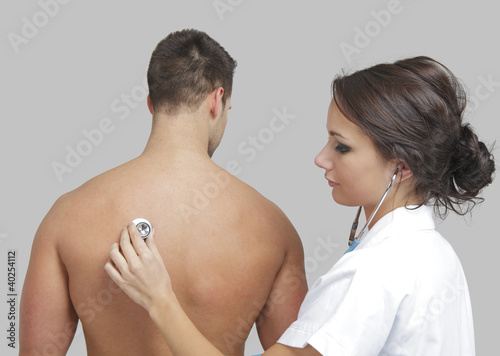 Photo: Young female doctor examining a male patient Young female doctor examining a male patient