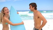 Woman taking her boyfriends's surfboard