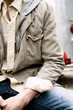 Photo: Young man sitting, midsection, close-up Young man sitting, midsection, close-up