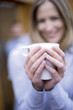 Woman holding mug, smiling, close-up