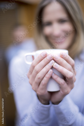 Photo: Woman holding mug, smiling, close-up Woman holding mug, smiling, close-up