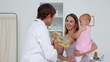 Doctor giving a teddy bear to a baby