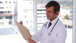 Doctor writing on a clipboard while standing