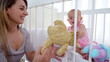 Mother watching her daughter playing with dolls