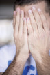 Man covering face with hands, close-up