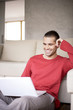 Young man looking at laptop, smiling