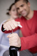 Young man opening wine bottle