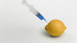 Syringe in super slow motion falling on a lemon