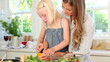 Mother and daughter cutting a pepper together