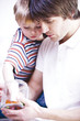 Father and son with sweet jar, side view