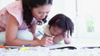 Mother helping her daughter with colouring