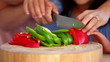 Girl with her mother preparing to cut a pepper