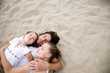 Parents with daughter lying on sand