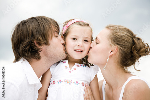 Photo: Parents kissing daughter Parents kissing daughter