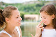 Mother applying cream on daughter's face