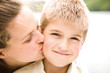 Mother kissing son, smiling, portrait