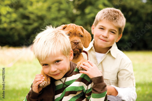 Photo: Boys playing with bulldog, portrait Boys playing with bulldog, portrait