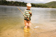 Boy holding fishing net in water, portrait