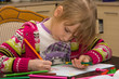 Little girl drawing with pencils at home