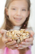 Little girl holding bowl with pistachios