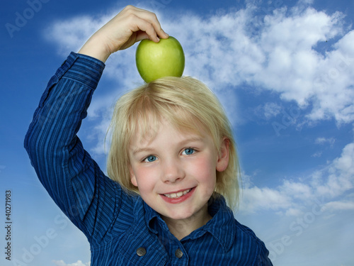 Photo: Cute girl balances her green apple eaten during break Cute girl balances her green apple eaten during break