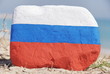 Russia flag painted over a stone over the sand