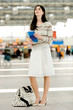 Young woman holding brochure at airport